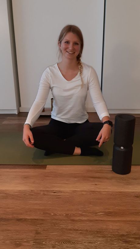 Janine Berger im Schneidersitz mit Faszien Rolle