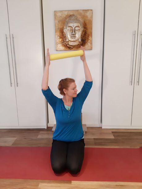 Meike Kämmerer, sitzender Twist mit gehobenen Armen und Poolnudel