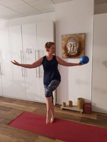 Meike Kämmerer, stehender Twist auf einem Bein mit Pilatesball